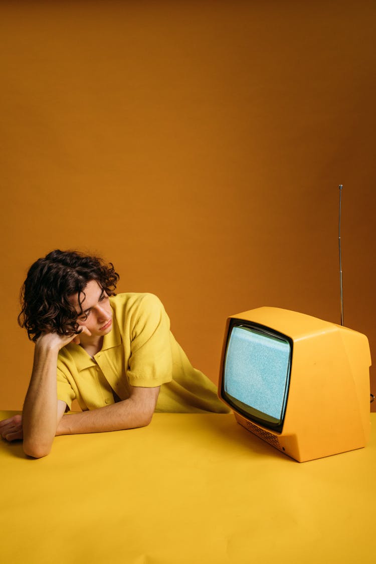 Young Man Eeling Bored Looking At A Tv With Blank Screen