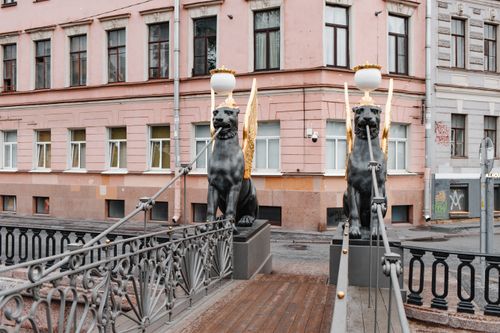Free Decorative gryphon statues on Bank Bridge in St. Petersburg, Russia with intricate metal railings and historic architecture. Stock Photo
