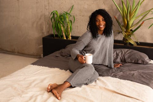 Free Woman Sitting on a Bed Stock Photo