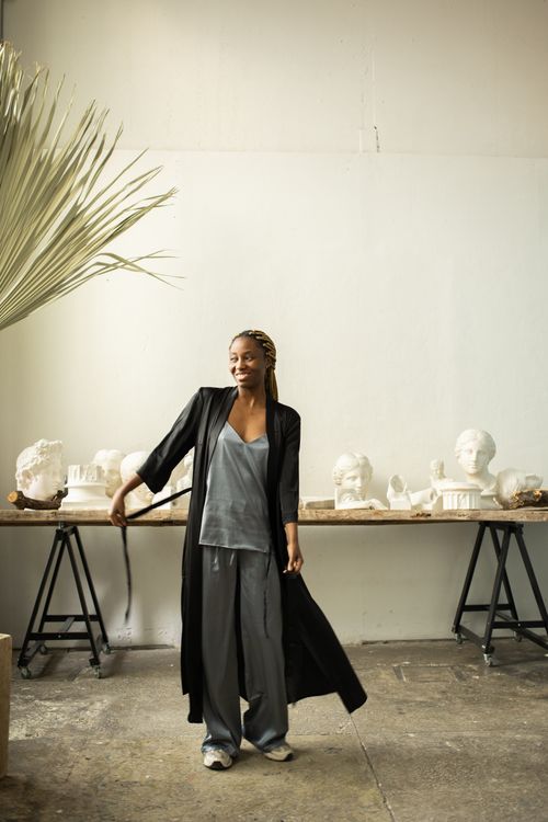 A Woman in Black Robe Standing on a Concrete Floor · Free Stock Photo