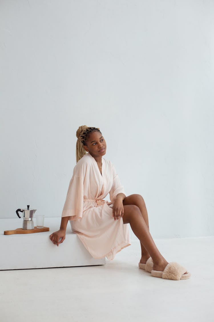 Woman In A Robe Sitting Near A Moka Pot