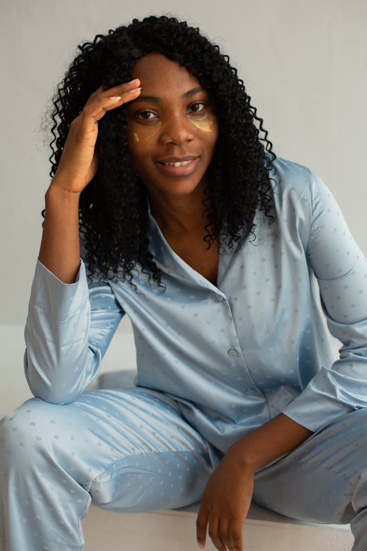 Photograph Of A Woman In Blue Pajamas With Under Eye Patches