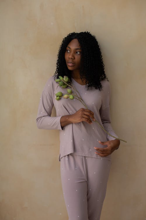 Free Woman Posing in Sleepwear and Holding a Flower  Stock Photo