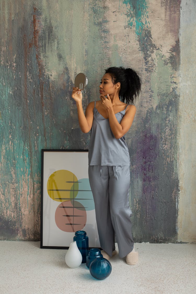 Beautiful Woman In Satin Pyjamas Holding A Mirror And Looking At Her Reflection 