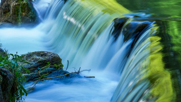A serene waterfall cascading over mossy rocks in Munich, Germany.