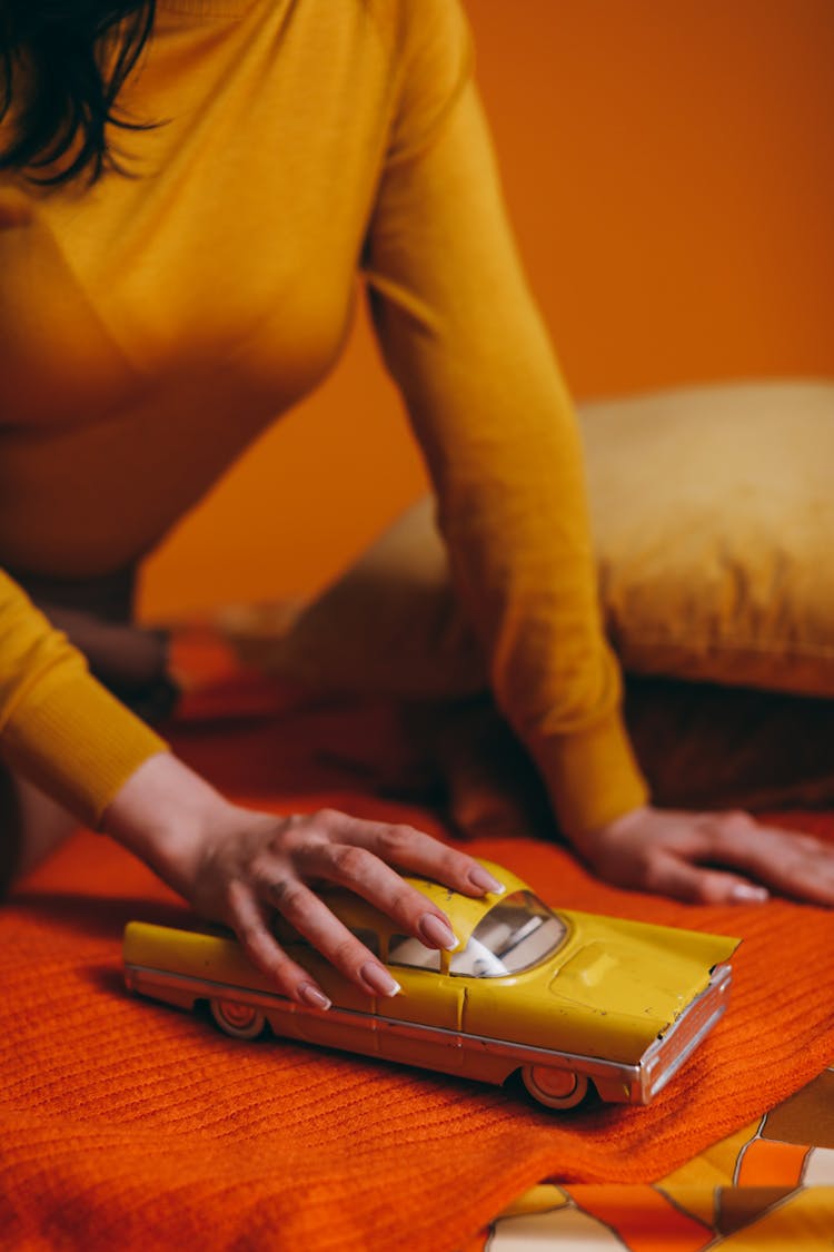 Woman Holding A Yellow Toy Car