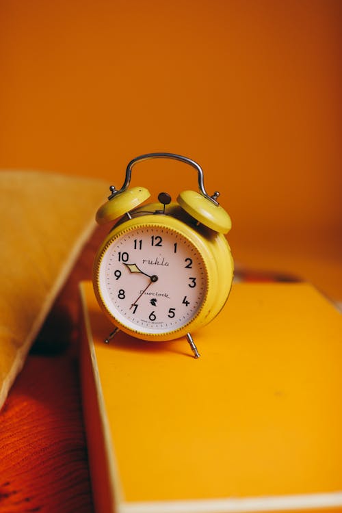 Reloj dorado con agujas despertador vintage sobre un fondo amarillo  brillante liso y aislado. Vista superior y de cerca. Copy space Photos