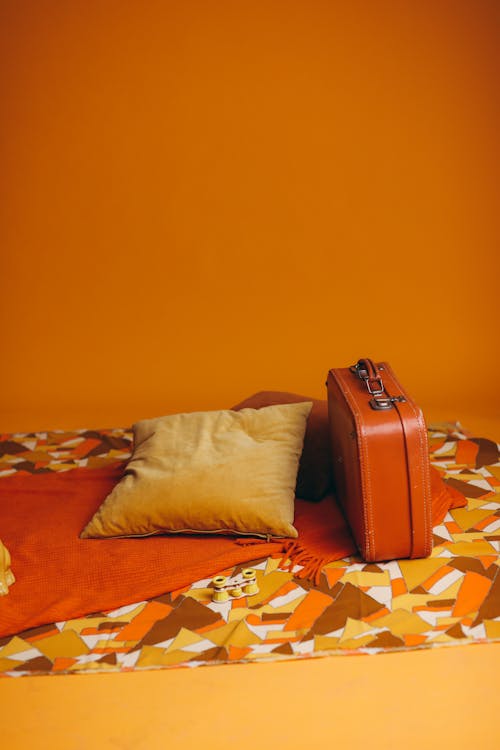 Brown Leather Suitcase Beside A Yellow Pillow