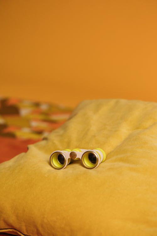 Free Yellow Binoculars On A Yellow Pillow Stock Photo