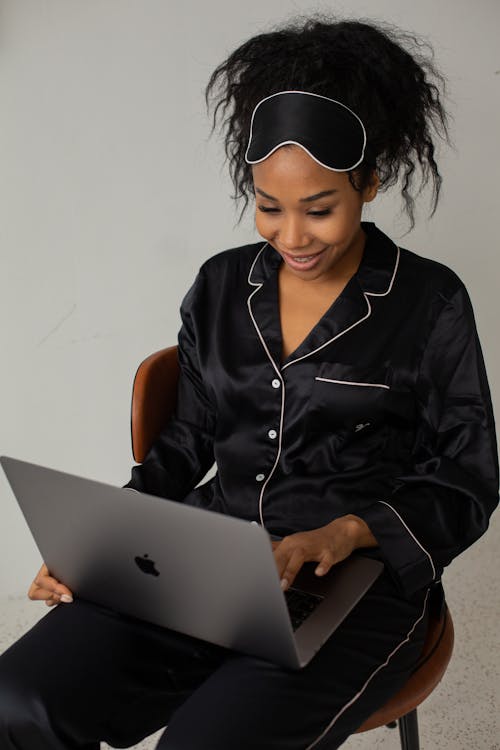 Free A Woman in Sleepwear Typing on a Laptop Stock Photo