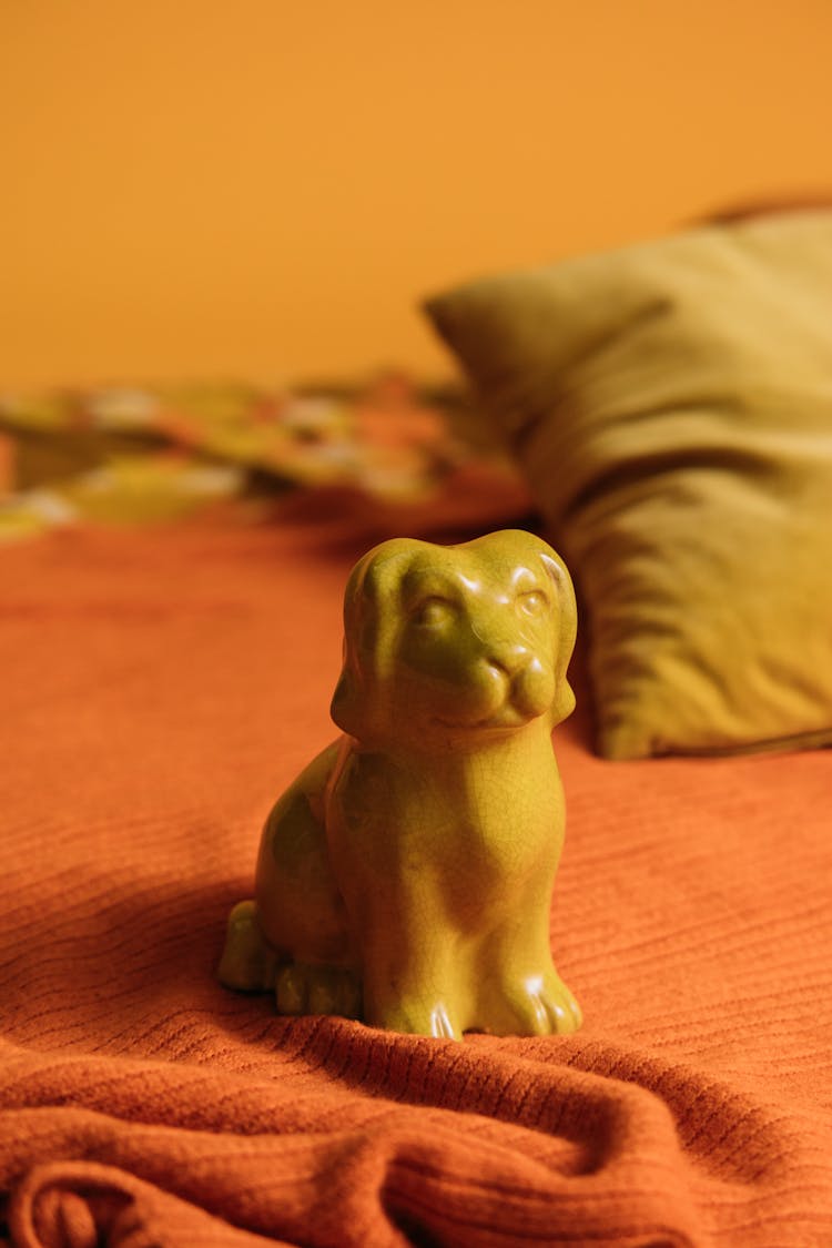 Yellow Dog Figurine On Bed