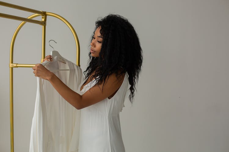 A Woman Holding A Robe In Hanger