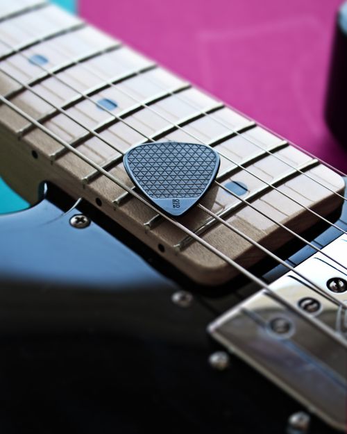Free Detailed close-up of an electric guitar with a textured guitar pick on the strings. Stock Photo