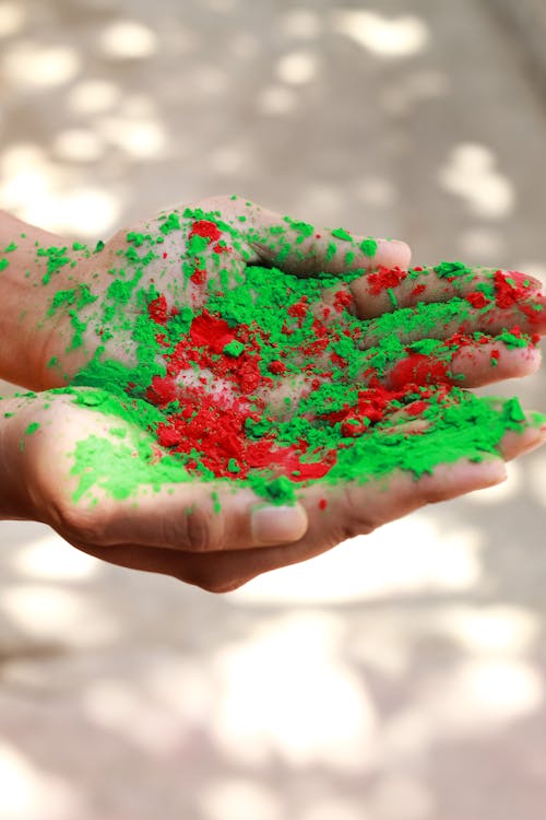 Free A Person's Hands with Green and Red Holi Powder Stock Photo