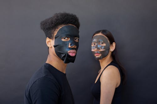 Free Serious diverse couple in facial masks Stock Photo