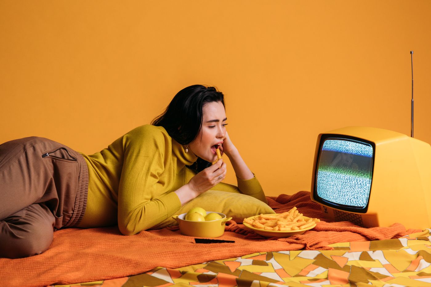 American viewer relaxing on a couch watching live television streamed through an Apple TV IPTV app