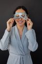 Smiling woman taking off sheet mask