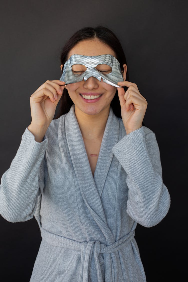 Smiling Woman Taking Off Sheet Mask