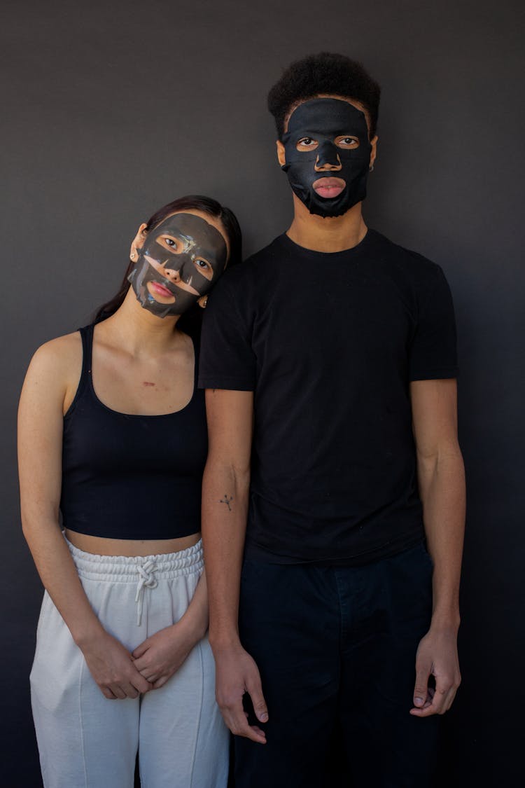 Asian Woman Standing Close To Black Man In Sheet Mask