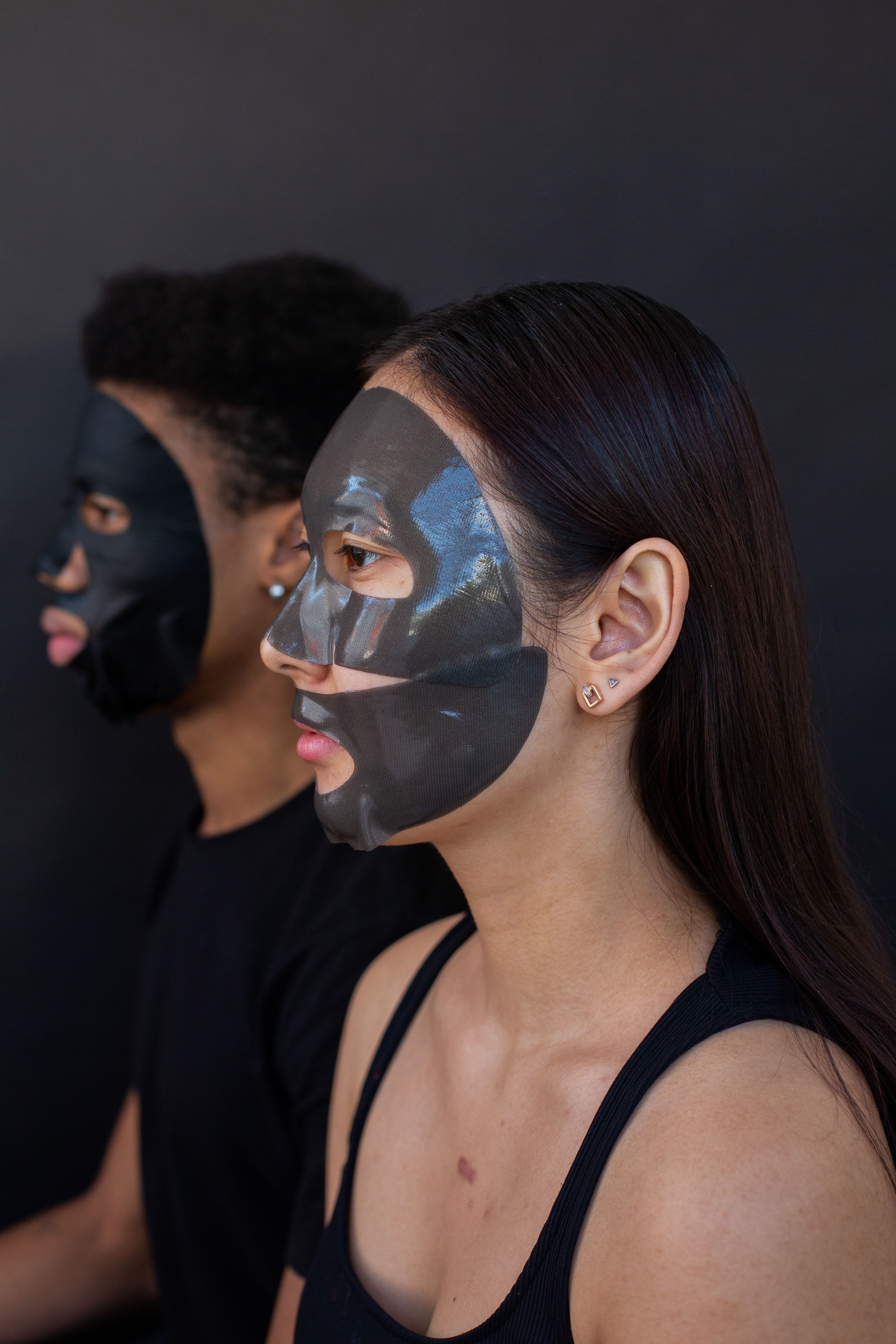 Multiethnic models with sheet masks on faces on dark background · Free ...