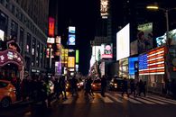 People Walking on Sidewalk during Night Time