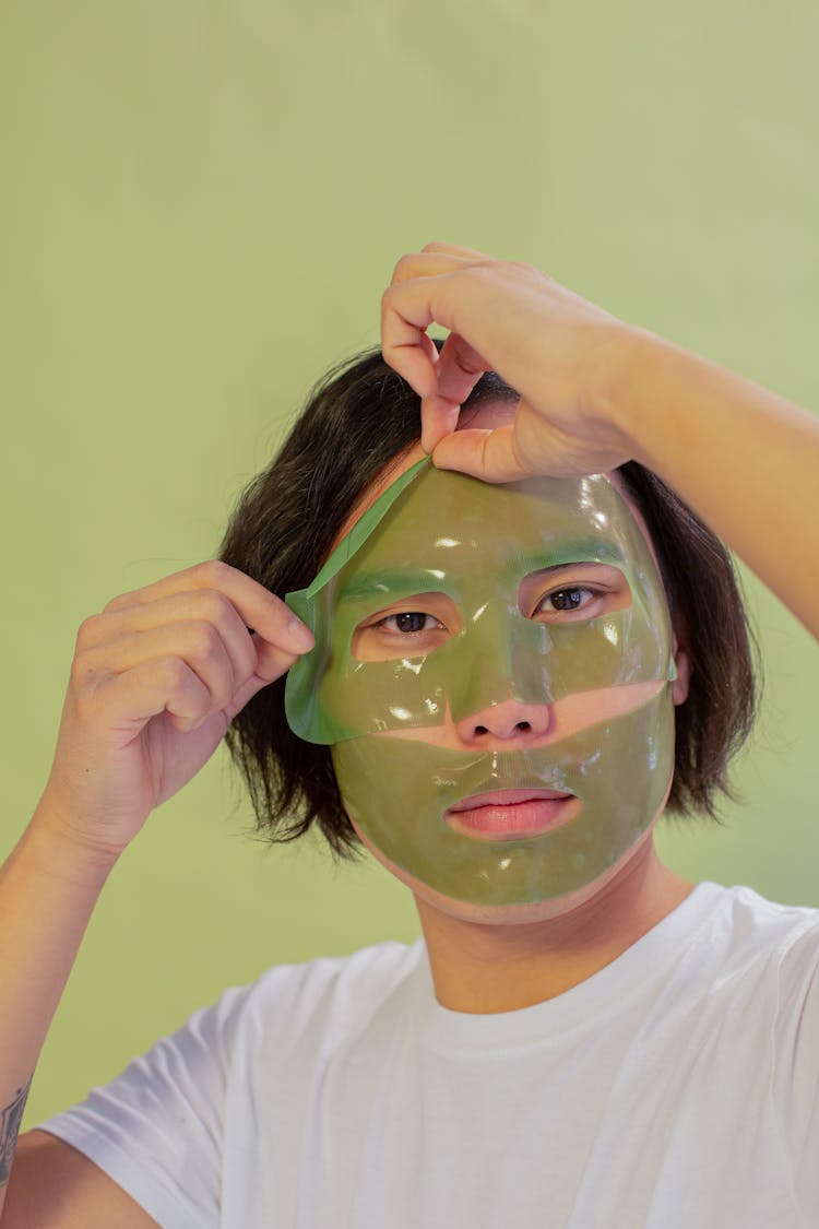 Asian Man Removing Hydrogel Mask From Face