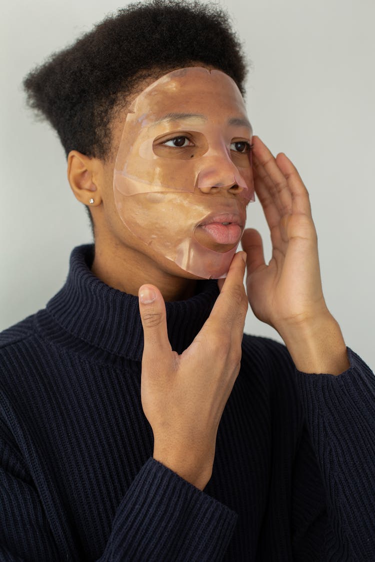 Black Man Applying Hydrogel Mask On Face