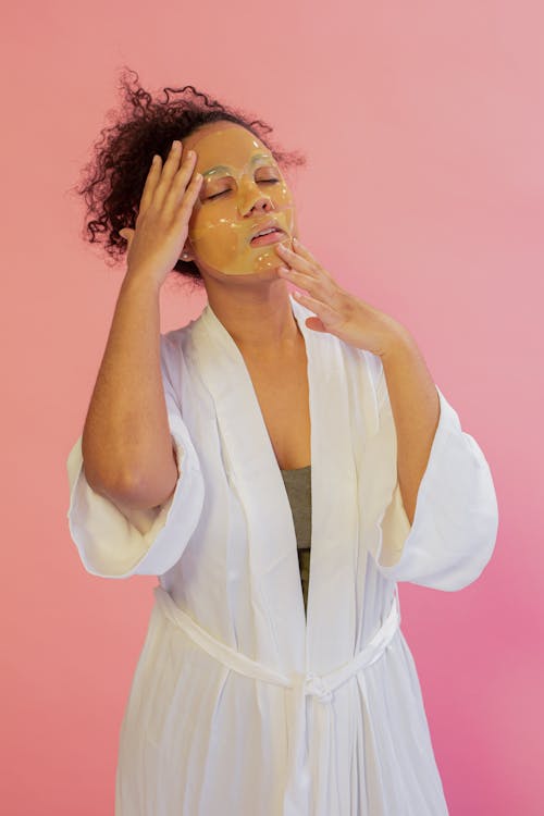 Black woman applying facial mask