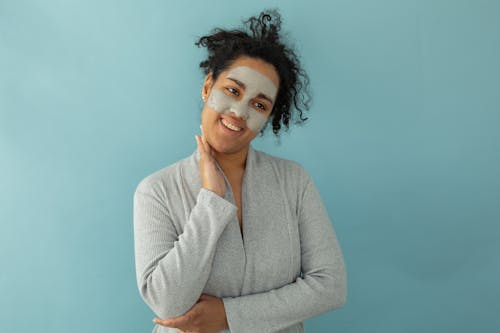 Free Woman in Gray Sweater with Facial Care Stock Photo