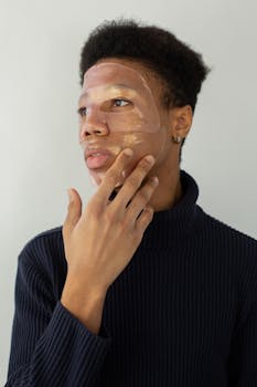 African American man applying a cosmetic facial mask for skincare routine.
