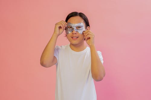 Free Man in Pink Background Putting a Mask Stock Photo