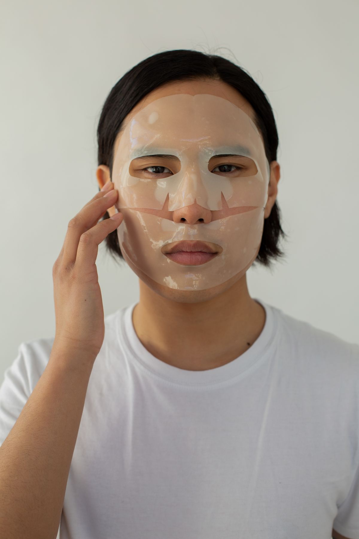 Man smoothing a sheet mask onto his face