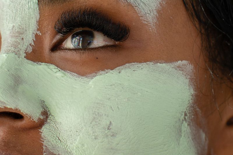 Femme avec un masque à l'argile verte sur le visage