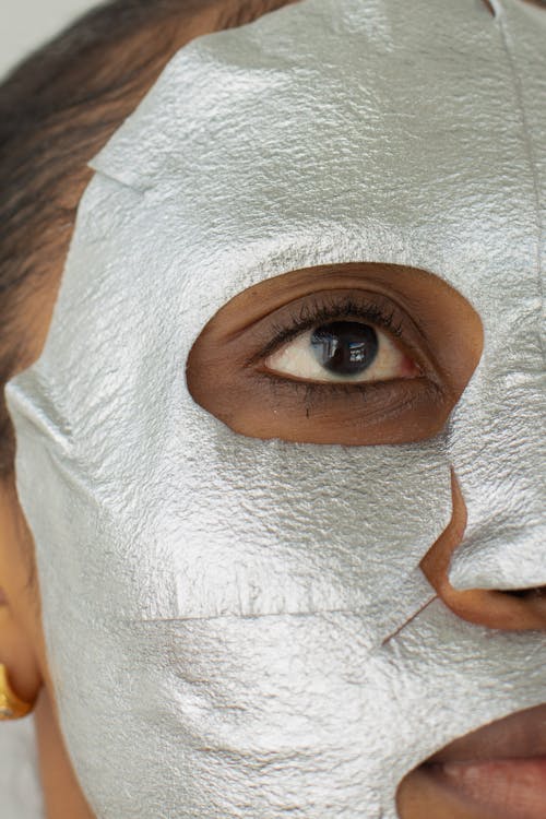 Unrecognizable black woman with gray facial mask