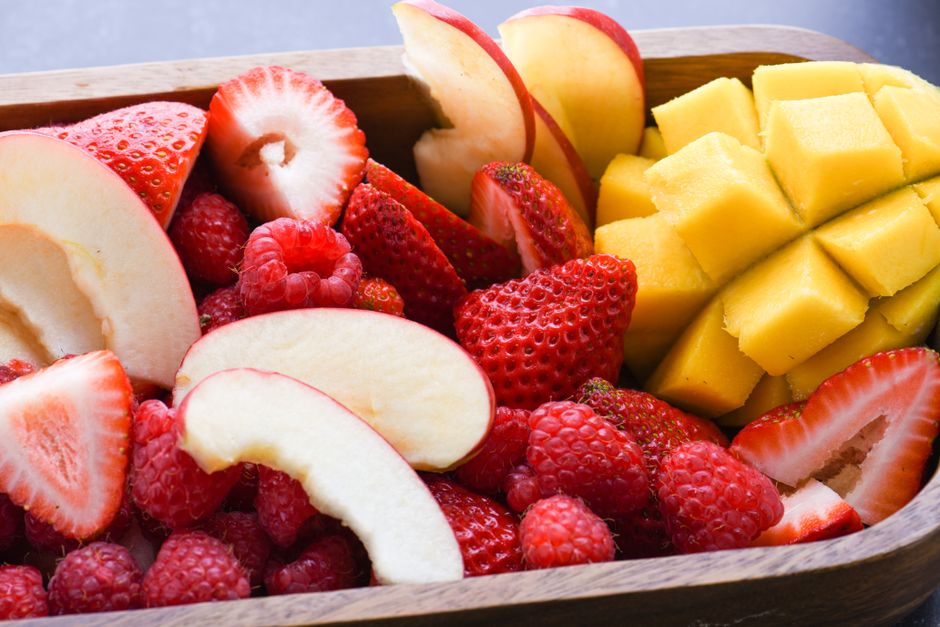 A colorful close-up of fresh sliced apples, strawberries, raspberries, and mango.