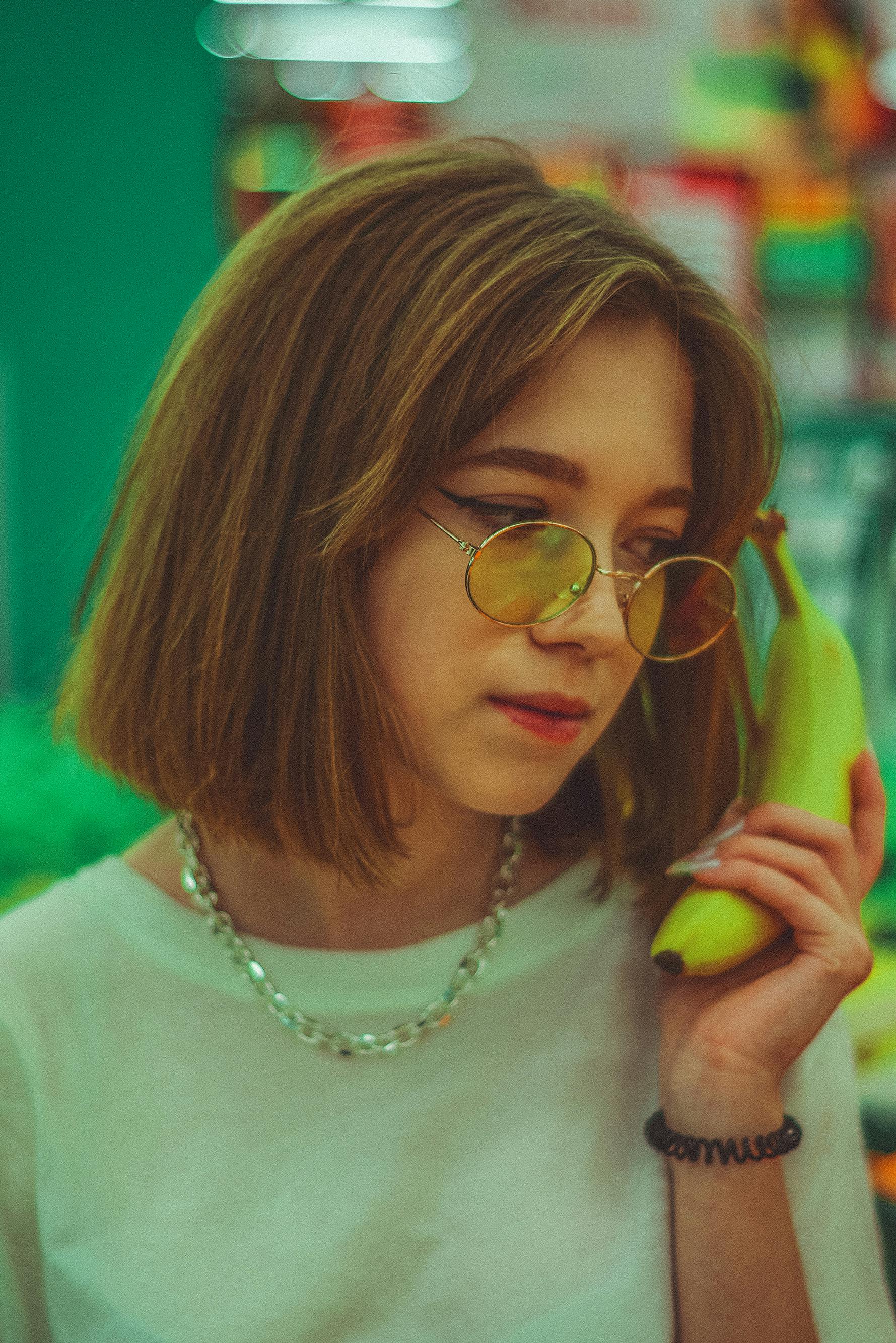 young woman holding a banana like a telephone