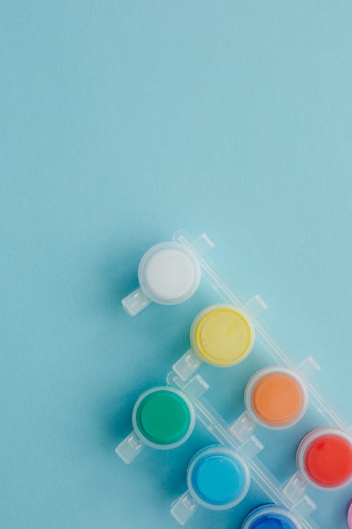 Close-Up Shot of Paints on a Blue Surface