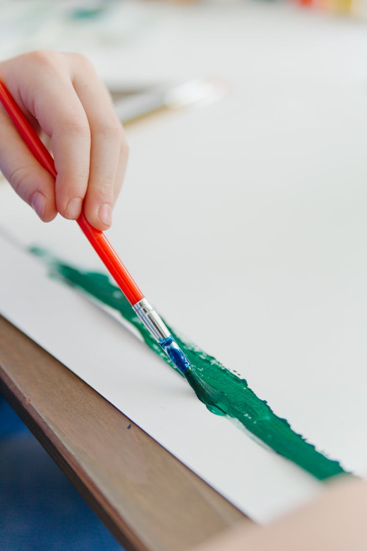 A Hand Painting A Line On A White Paper