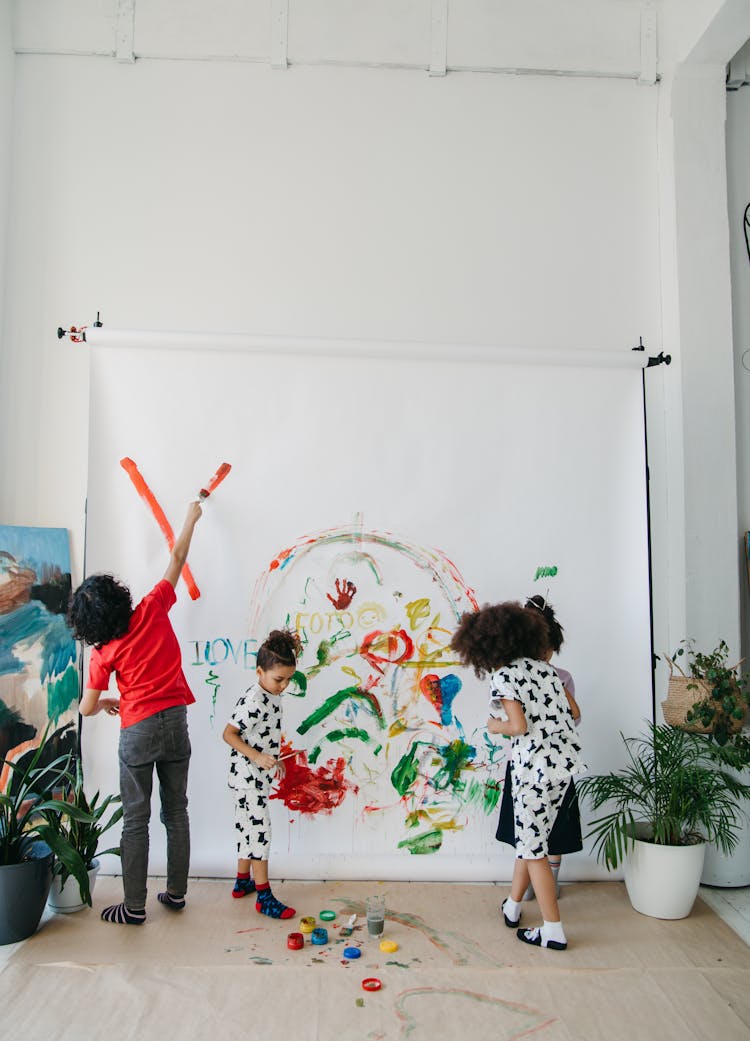 Kids Painting On A White Wall