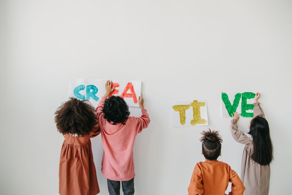 Photo by Anastasia Shuraeva on Pexels Kids displaying colorful 'CREATIVE' posters on a white wall indoors. - Photo by Anastasia Shuraeva on Pexels