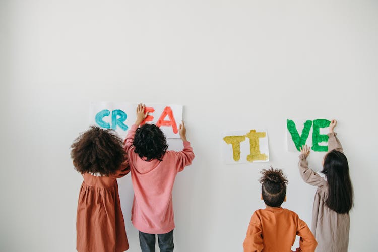 Kids Posting The Artwork On A White Wall