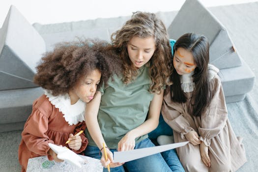 A teacher guides two children in an artistic activity indoors, using paper and pencils.