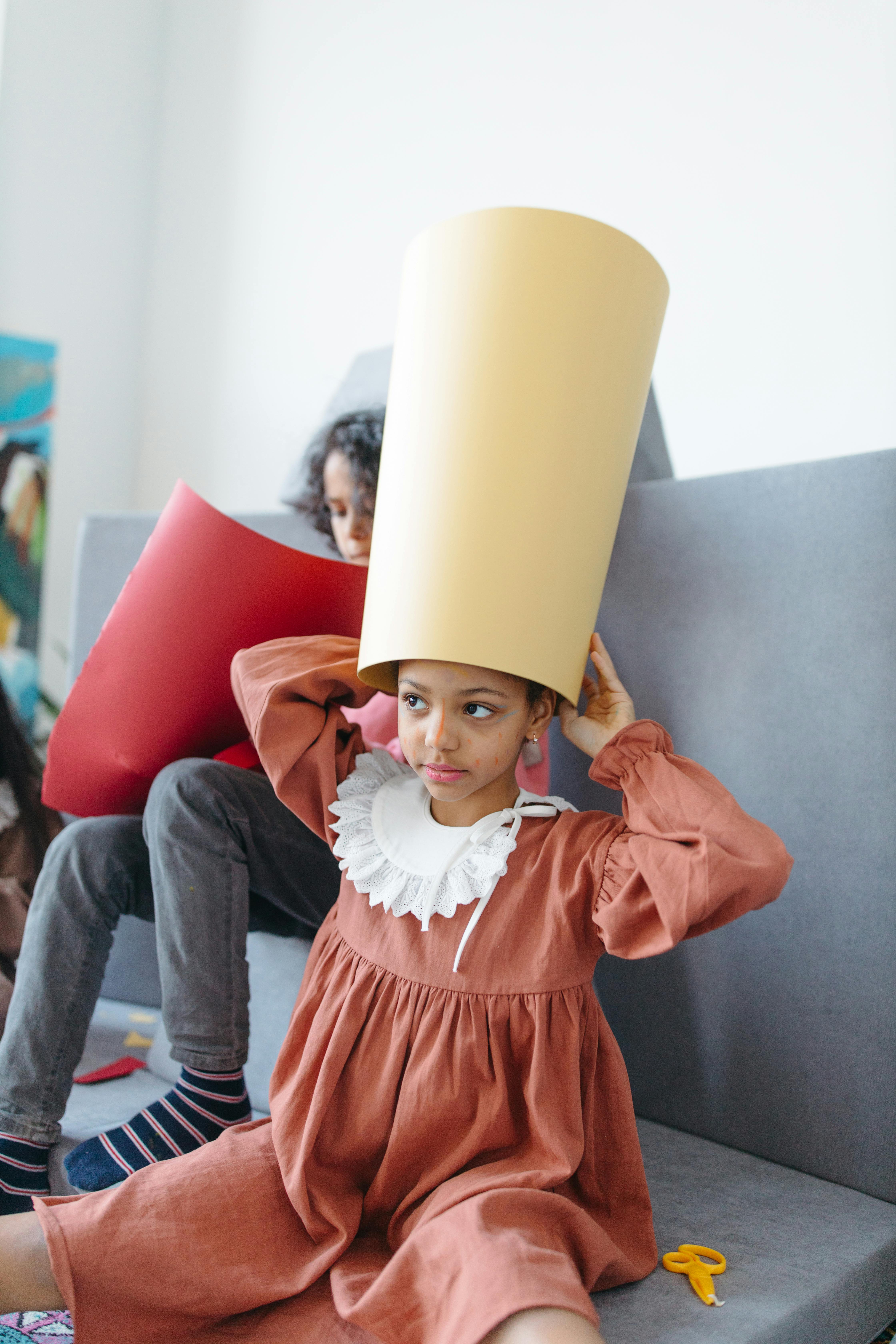 a girl holding a beige cardboard on her head