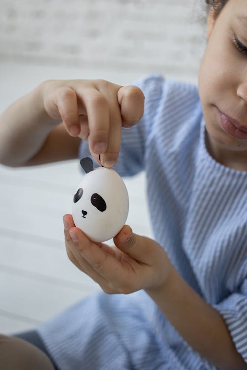 Close-Up Shot of a Girl Holding and Designing an Egg