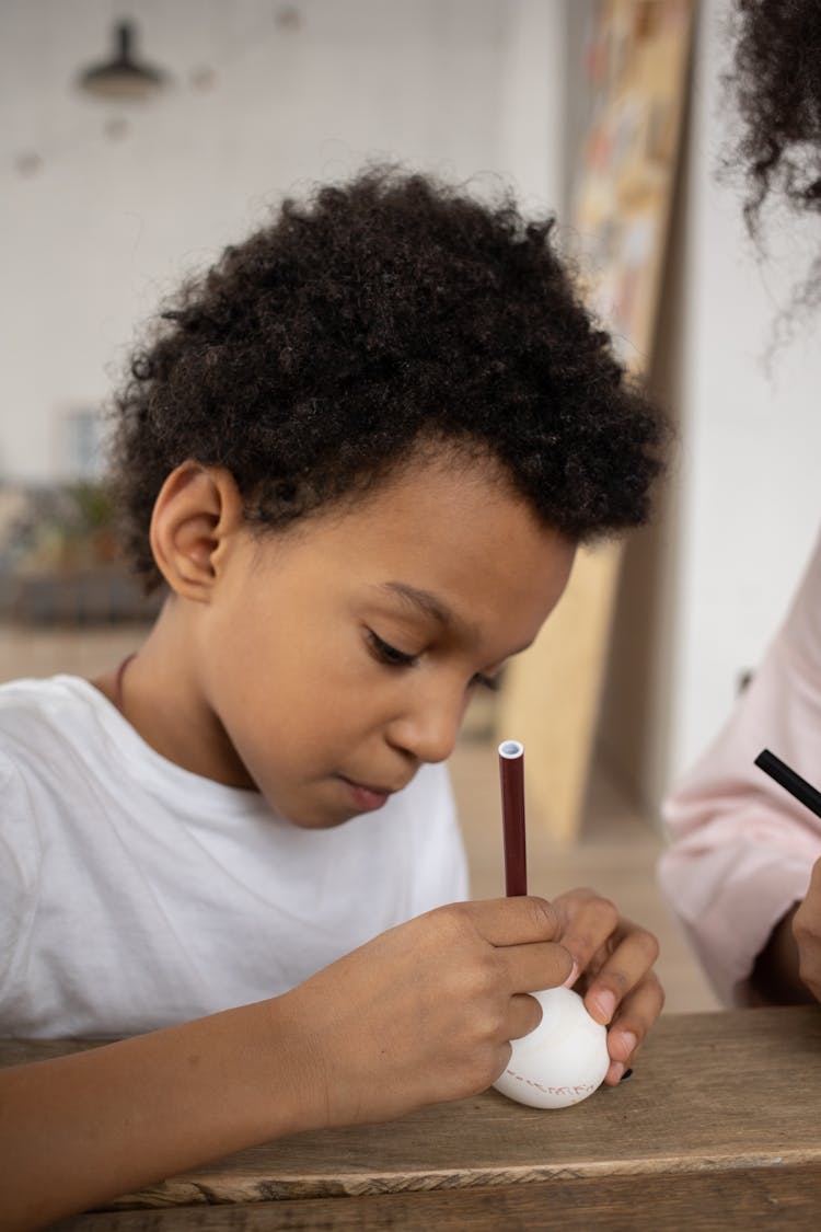 Little Boy Painting An Egg For Easter 