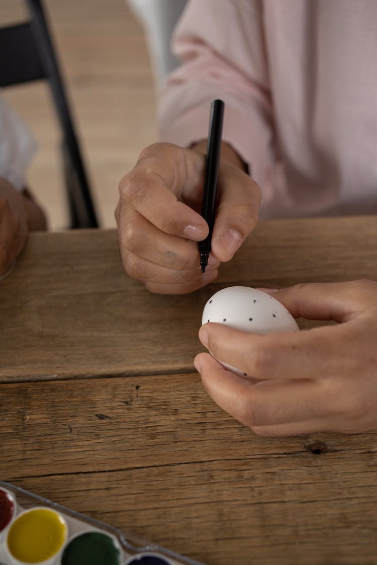 Hand Decorating Egg With Dots