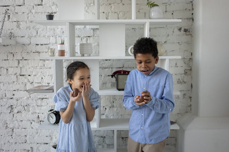 Siblings Laughing While Eating Chocolate Eggs