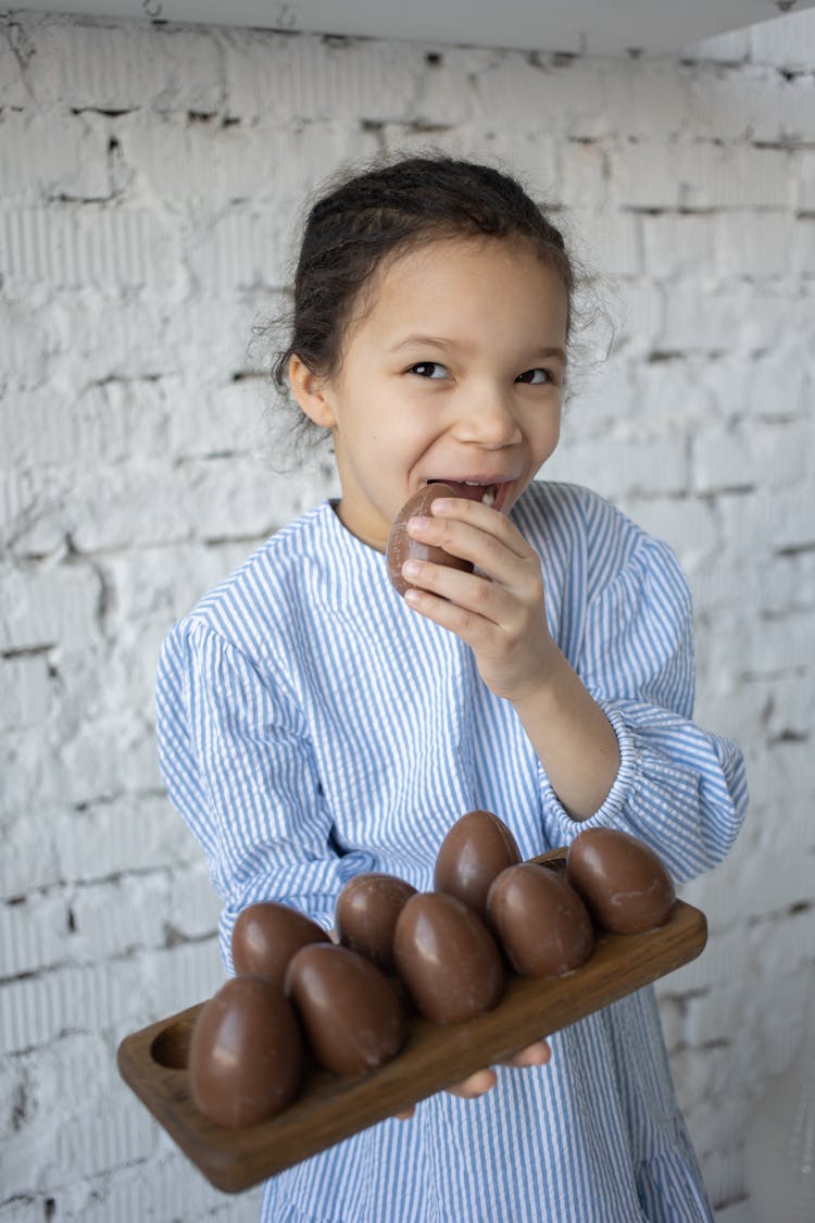 Little Girl Holding Tray Of Chocolate Eggs