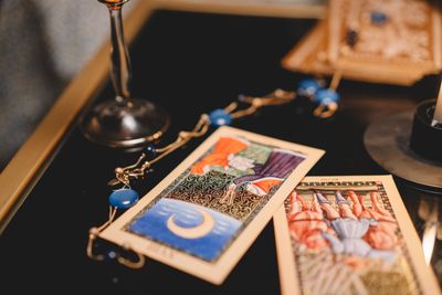 Two cards laid beside a small lamp on a dark table