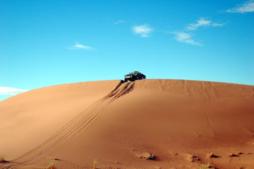 Car on Top of Sand Cliff during Day Time